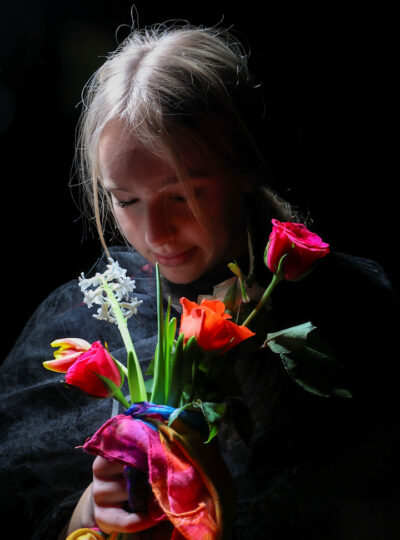 Hidden Polution (photograph of a girl holding vibrantly coloured flowers)